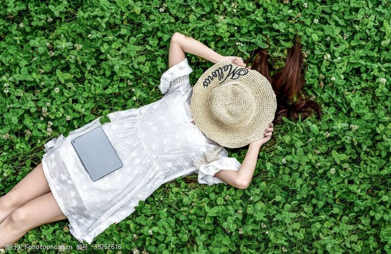 春天的背景躺在草地戴帽子的女孩图片