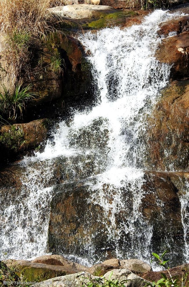 清澈的水山石上流淌而下的瀑布图片