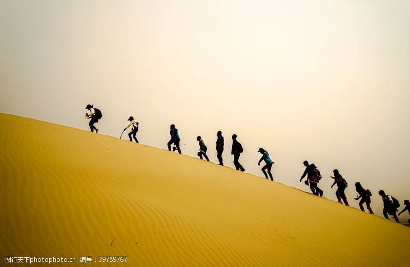 冒险沙漠中行进的人群图片