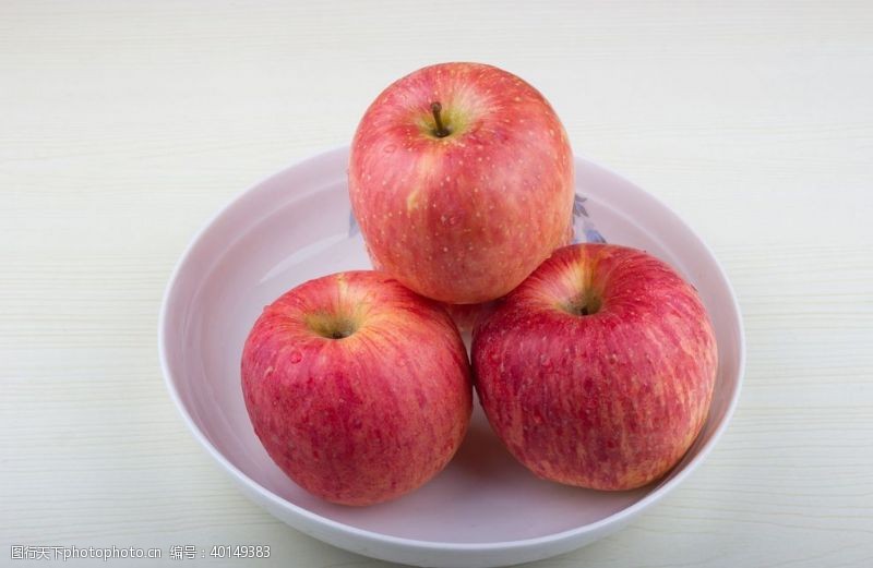 红果子盘子里的苹果特写图片